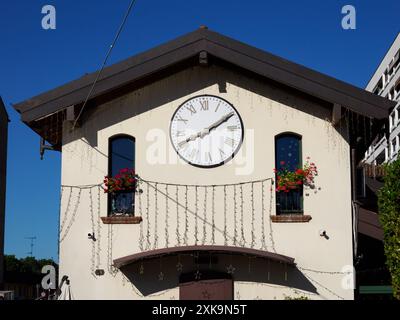 Äußere eines seltsamen Hauses in Trezzano sul Naviglio, Mailand, Lombardei, Italien, mit einer großen Uhr Stockfoto