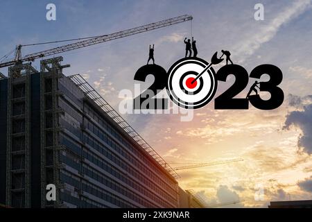 Silhouette des Arbeitsteams, das sich auf das neue Jahr 2023 vorbereitet. Silhouette eines Bauarbeiters mit einem Kran, der sich auf das neue Jahr vorbereitet Stockfoto