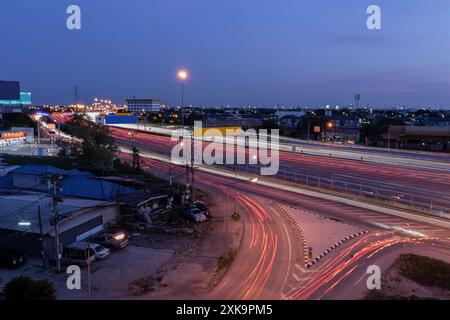 Langzeitaufnahme des Verkehrs während der Nachtfahrt auf einer Autobahn in Thailand. Abstrakte animierte kurvige Stadtstraße mit Neonlicht-Bewegungseffekt-App Stockfoto