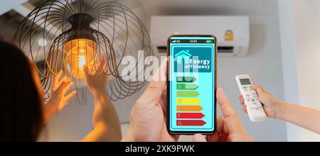 Frau wechselt eine neue elektrische Glühlampe, offene Klimaanlage 26 Grad macht ein Zuhause energieeffizienter. Haushaltsgerät energieeffizient. Haushaltsgeräte Stockfoto