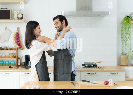 Ein junges verliebtes Paar, das Spaß hat, während es an einem schönen Morgen ein gemeinsames Frühstück zubereitete. Kochen, zusammen, Küche, Beziehung. Ein paar Abnutzungen Stockfoto