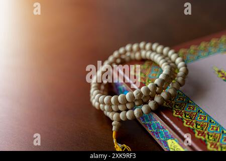 Heilig-islamischer Buchkoran mit Rosenkranzperlen auf hölzernem Hintergrund. Quran mit schriftlicher arabischer Kalligraphie Bedeutung des Al-Quran. Ramadan Mubarak. Ramadan ka Stockfoto