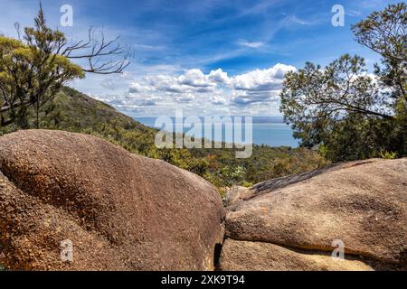 Die roten Felsbrocken und Eukalyptuswald des Freycinet National Park mit Blick auf die Wine Glass Bay. Sommer in Tasmanien, Australien. Stockfoto