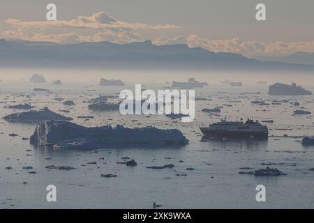 Hurtigruten Schiff zwischen Eisbergen und Eisschollen bei Mitternachtssonne, Sommer, Jacobshavn Gletscher, Kangerlua Icefjord, Disko Bay, Ilulissat, Grönland Stockfoto