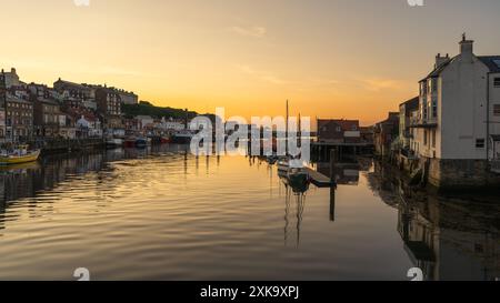 Whitby, North Yorkshire, England, Großbritannien - 21. Juni 2023: Golden Hour über der Stadt und dem Fluss Esk, von der Whitby Bridge aus gesehen Stockfoto