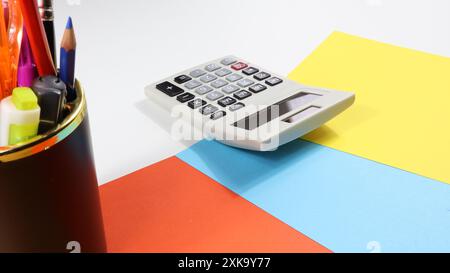 Bunte Kopierflächen auf dem Schreibtisch mit Taschenrechner und Stifthalter. Stockfoto