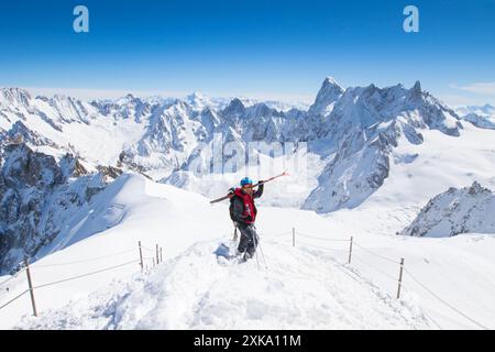 Ein männlicher Freerider geht von der Aiguille du Midi, einer 3842 Meter hohen Seilbahnstation, die Zugang zur berühmten Vallee Blanche bietet, einer Skiabfahrt in die Berge Stockfoto