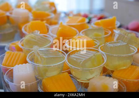 Verschiedene farbige Gelees in Plastikbechern am Buffet Stockfoto