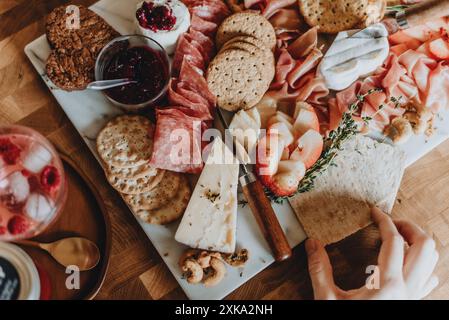 Wurstplatte mit Aufschnitt, Käse, Cracker und Obst. Stockfoto