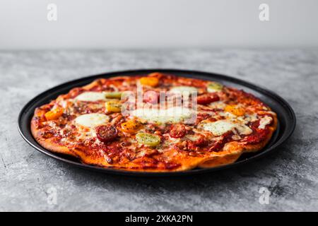 margherita Pizza mit Kirschtomaten und herzförmigem Käse in der Mitte, hausgemachte Rezepte Stockfoto