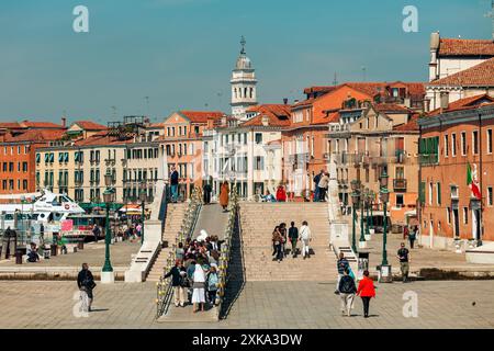 Menschen laufen auf der Straße entlang alter traditioneller Gebäude in Venedig, Italien. Stockfoto