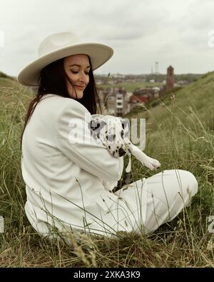 Junge Frau mit Mohn posiert vor wunderschöner Aussicht Stockfoto