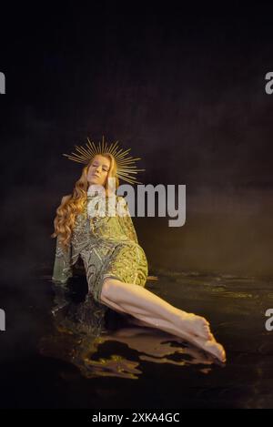 Blonde Frau im kurzen Kleid mit Pailletten und Krone im Wasser Stockfoto