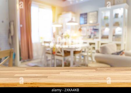 Holztische, Holzregale im Vordergrund. Defokussiertes Bild eines Geschäfts oder Cafés mit bokeh farbenfrohen Lichtern im Hintergrund. Innenraum des Wohnzimmers verschwommen Stockfoto