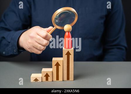 Ein Geschäftsmann studiert seinen Gegner und seine Karriere. Führungskompetenzen. Nimm die Gegner auf Platz. Stockfoto