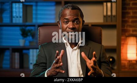 Seriöser professioneller Geschäftsmann, der in die Kamera schaut und auf Videoanruf verhandelt, intelligenter Erwachsener, männlicher Lehrer, spricht bei einer Online-Konferenz und erklärt Informationen Stockfoto