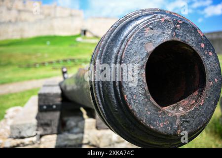 Alte, verwitterte Kanone, die auf feindliche Linien zeigt und eine Festung schützt. Stockfoto