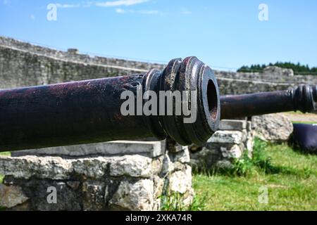 Alte, verwitterte Kanone, die auf feindliche Linien zeigt und eine Festung schützt. Stockfoto