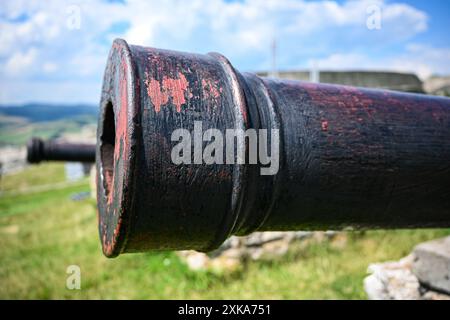 Alte, verwitterte Kanone, die auf feindliche Linien zeigt und eine Festung schützt. Stockfoto