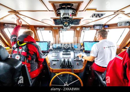 Hooksiel, Deutschland. Juli 2024. Seerettler sitzen an Bord des Rettungskreuzers Bernhard Gruben. Die Deutsche Seeschiffssuche und -Rettung (DGzRS) hält ihren traditionellen Aktionstag am 28. Juli ab. Es wird Demonstrationen, Übungen und Präsentationen an Rettungsstationen an der Nord- und Ostküste geben. Quelle: Sina Schuldt/dpa/Alamy Live News Stockfoto