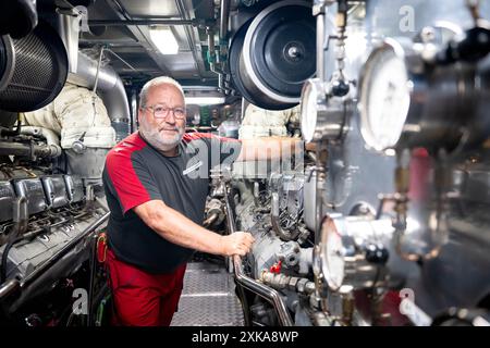 Hooksiel, Deutschland. Juli 2024. Frank Heiken steht im Maschinenraum des Rettungskreuzers Bernhard Gruben. Die Deutsche Seeschiffssuche und -Rettung (DGzRS) hält ihren traditionellen Aktionstag am 28. Juli ab. Demonstrationen, Übungen und Präsentationen finden an Rettungsstationen an der Nord- und Ostküste statt. Quelle: Sina Schuldt/dpa/Alamy Live News Stockfoto