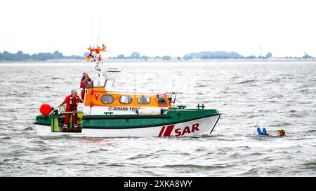 Hooksiel, Deutschland. Juli 2024. Die Seerettler absolvieren eine Rettungsübung mit dem Tochterboot Johann FIDI des Rettungskreuzers Bernhard Gruben. Die Deutsche Seeschiffssuche und -Rettung (DGzRS) hält ihren traditionellen Aktionstag am 28. Juli ab. Es wird Demonstrationen, Übungen und Präsentationen an Rettungsstationen an der Nord- und Ostküste geben. Quelle: Sina Schuldt/dpa/Alamy Live News Stockfoto