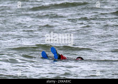 Hooksiel, Deutschland. Juli 2024. Ein Mann driftet in der Nordsee während einer Rettungsübung durch Seerettler. Die Deutsche Seeschiffssuche und -Rettung (DGzRS) hält ihren traditionellen Aktionstag am 28. Juli ab. Es wird Demonstrationen, Übungen und Präsentationen an Rettungsstationen an der Nord- und Ostküste geben. Quelle: Sina Schuldt/dpa/Alamy Live News Stockfoto