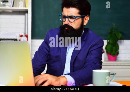 Männlicher Student der Universität, der sich auf die Prüfung oder Prüfung im Klassenzimmer vorbereitet. Bildung, Lernen und Wissen. Seriöser Lehrer, Hochschullehrer oder Stockfoto