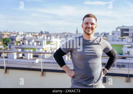 Glücklicher bärtiger, gutaussehender Mann, der mit einer Matte und einer Flasche Wasser in der Hand ins Fitnessstudio geht oder Yoga übt. Gehen Stockfoto
