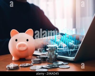 Online-Banking, Investitionen, Sparen, Börse und digitales Finanzkonzept. Schweinebank mit Münzstapeln in der Nähe des digitalen Handelsgraphen-Diagramms gro Stockfoto