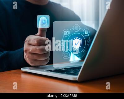 Fingerabdruck-Scan-Zugriffstechnologie auf dem Daumen eines Geschäftsmannes, biometrische Identifikation, während Symbole für persönliche Daten auf dem Laptop-Bildschirm angezeigt werden. Cybersicherheit, Stockfoto