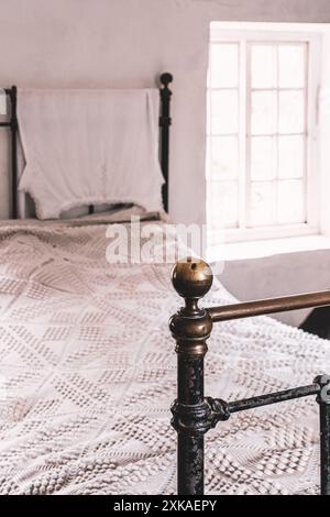 Edwardianisches Häuschen aus Messing in einem Schlafzimmer am Morwellham Quay in Devon. Stockfoto