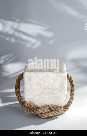 Marmorsteinwürfel Standfuß mit Kopierraum für Produkte und Herbsthintergrund mit Herbstbaumblättern. Weißes Sonnenlicht an der Wand Stockfoto