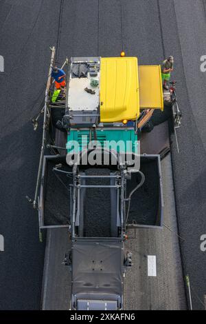 Essen, Nordrhein-Westfalen, Deutschland - Strassenbau, Asphaltfertiger und Strassenwalzen verbauen neu, offenporigen, Fluesterasphalt auf der Autobahn A52, hier zwischen den Anschlussstellen Essen-Kettwig und Essen-Ruettenscheid in Fahrtrichtung Dortmund. Essen Nordrhein-Westfalen Deutschland *** Essen, Nordrhein-Westfalen, Deutschland Straßenbau, Asphaltfertiger und Straßenwalzen legen auf der Autobahn A52, hier zwischen den Anschlussstellen Essen Kettwig und Essen Ruettenscheid in Richtung Dortmund Essen Nordrhein-Westfalen Deutschland, neuen, offenporigen, fluessigen Asphalt ab Stockfoto