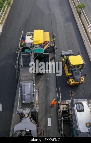 Essen, Nordrhein-Westfalen, Deutschland - Strassenbau, Asphaltfertiger und Strassenwalzen verbauen neu, offenporigen, Fluesterasphalt auf der Autobahn A52, hier zwischen den Anschlussstellen Essen-Kettwig und Essen-Ruettenscheid in Fahrtrichtung Dortmund. Essen Nordrhein-Westfalen Deutschland *** Essen, Nordrhein-Westfalen, Deutschland Straßenbau, Asphaltfertiger und Straßenwalzen legen auf der Autobahn A52, hier zwischen den Anschlussstellen Essen Kettwig und Essen Ruettenscheid in Richtung Dortmund Essen Nordrhein-Westfalen Deutschland, neuen, offenporigen, fluessigen Asphalt ab Stockfoto