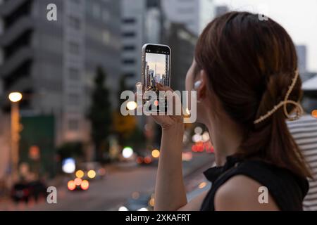 Tokio, Japan. Juli 2024. Eine Frau fotografiert den Tokyo Tower mit ihrem Handy. Quelle: SOPA Images Limited/Alamy Live News Stockfoto