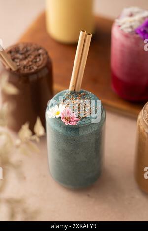 Auswahl an farbenfrohen Smoothies, wunderschön dekoriert, am Coffee Shop Tisch. Stockfoto