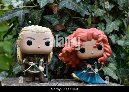 Funko Pop Actionfiguren von Elf Legolas aus dem Film der Herr der Ringe und Prinzessin Merida aus dem Zeichentrickfilm Brave. Bogenschützen im Efeu-grünen Wald. Stockfoto