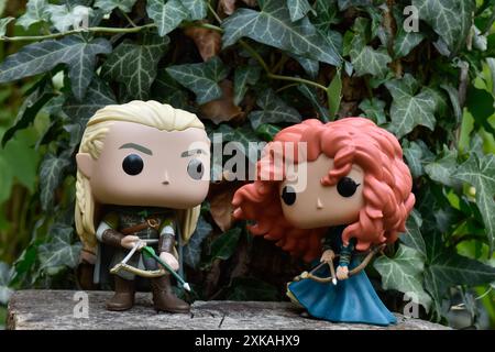 Funko Pop Actionfiguren von Elf Legolas aus dem Film der Herr der Ringe und Prinzessin Merida aus dem Zeichentrickfilm Brave. Bogenschützen im Efeu-grünen Wald. Stockfoto