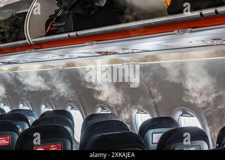 An einem sehr heißen Sommertag bildet sich in einer Flugzeugkabine Nebel oder Wolken in der Kabine, da heiße Außenluft auf den kühlen, klimatisierten Innenraum trifft Stockfoto