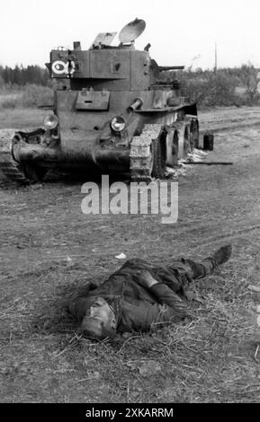 Totes Besatzungsmitglied vor einem ausgebrannten russischen BT-Panzer. [Automatisierte Übersetzung] Stockfoto