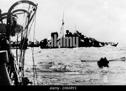 Der britische Zerstörer Kolly versinkt, nachdem er von einem Torpedo getroffen wurde. Vor ihm, Mitglieder der Crew in einem Rettungsboot. [Automatisierte Übersetzung] Stockfoto