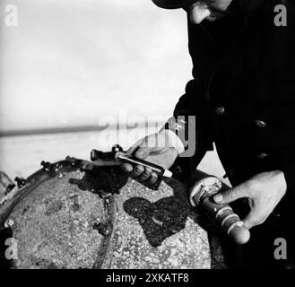 Bei der Entschärfung einer Meeresmine, die am Strand angespült war, löste ein deutscher Soldat einen der Spitzen und hielt das mit Chromsäure gefüllte Glasrohr des Zünders in der Hand. [Automatisierte Übersetzung] Stockfoto