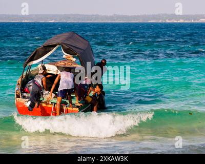 Sansibar, Tansania - Jan, 2021: Boot mit einer Gruppe afrikanischer Männer, die auf Prison Island (auch bekannt als Changuu, Quarantine Island i Kibandiko) festmachen. Heute Stockfoto