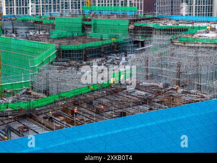 HUAI'AN, CHINA - 22. JULI 2024 - Arbeiter arbeiten auf der Baustelle eines im Bau befindlichen Immobilienprojekts in Q mit hohen Temperaturen Stockfoto