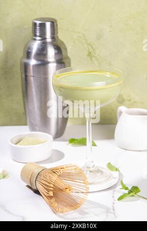 Cremiger Matcha-Martini-Cocktail Matchatini, trendiger kalter Sommercocktail. Matcha alkoholfreier Mocktail oder Alkohol Cocktail, in Martini Gläsern mit GREE Stockfoto