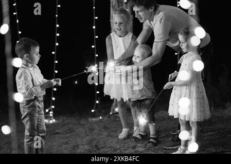 Sparkler bei der Hochzeit der Frischvermählten in den Händen fröhlicher Gäste Stockfoto