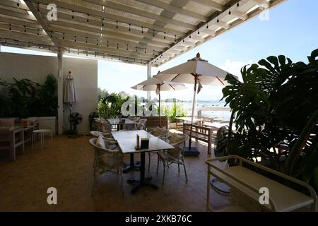 Ein Tisch zum Essen in einem Restaurant an der trockenen Küste mit Blick auf Sand, Felsen und Himmel an einem klaren Tag in Samae San Bay, Provinz Chonburi, Thaila Stockfoto