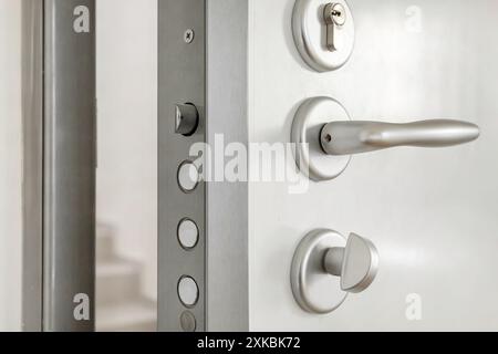 Nahaufnahme: Hochsicherheitsschloss einer weißen gepanzerten Haustür Stockfoto