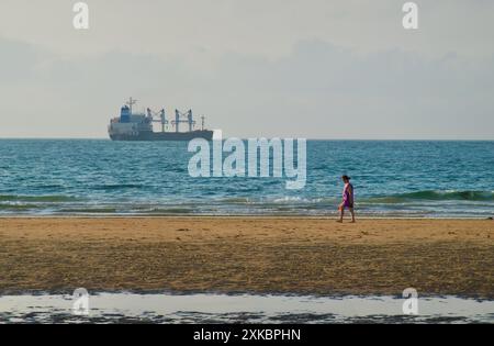 Massengutschiff Alma verlässt den Hafen von Santander vom Strand von Somo aus gesehen mit einer Person, die Ribamontán al Mar Cantabria Spanien spaziert Stockfoto